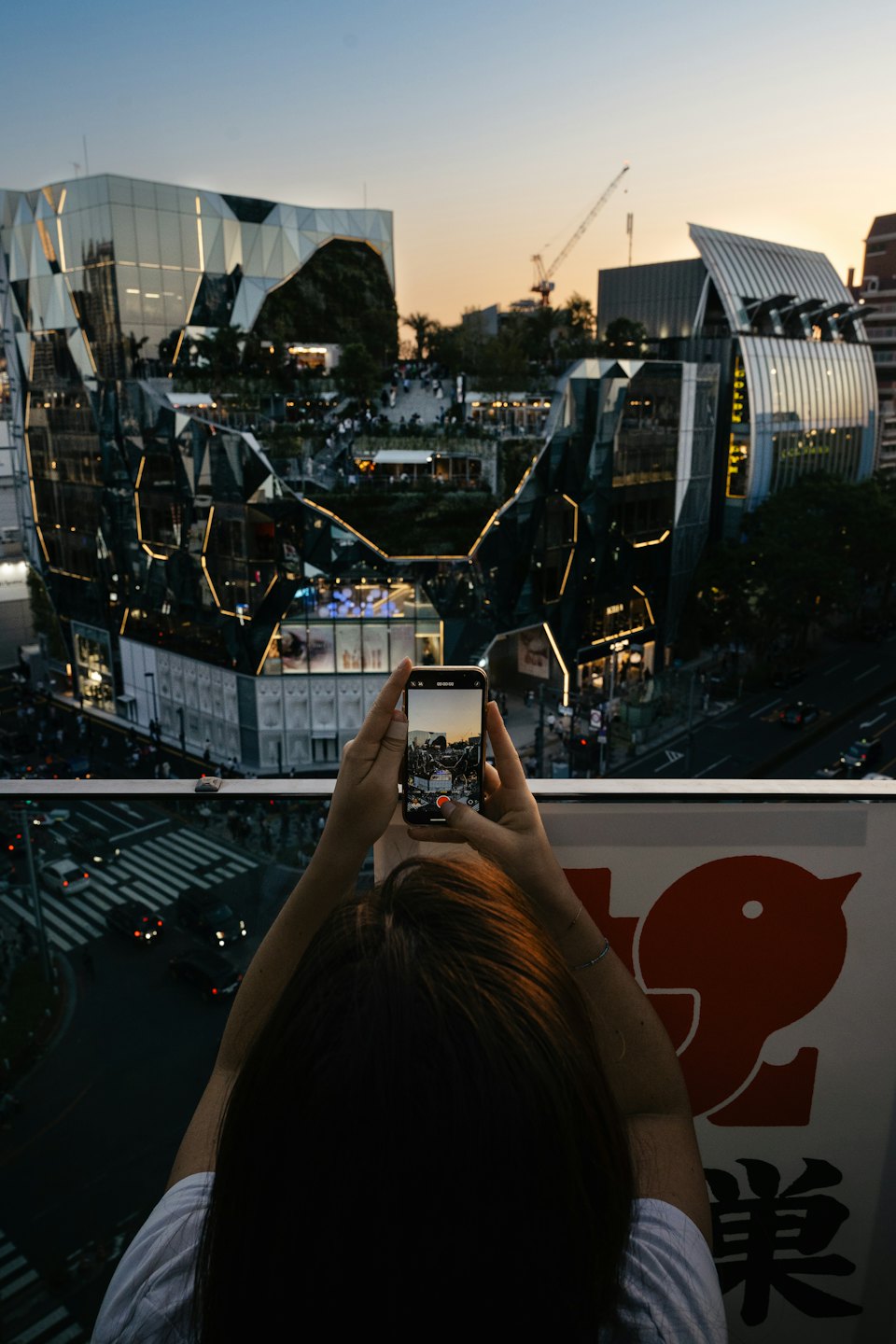 Persona fotografa lo skyline della città al tramonto dall'alto.
